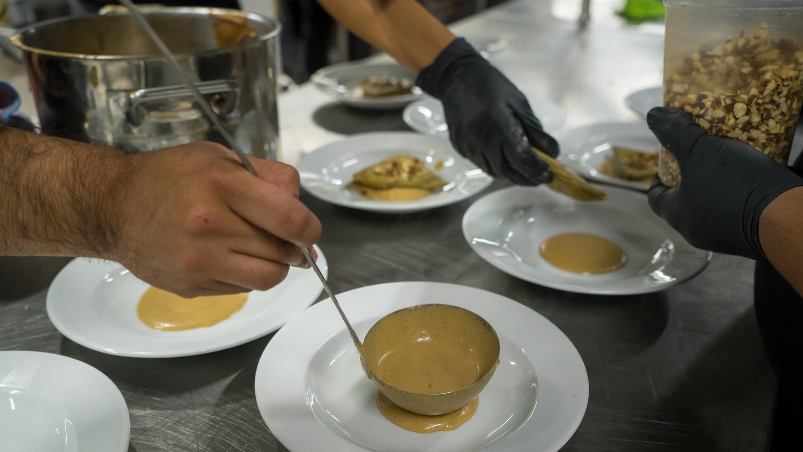 Chef Steve Ingber plating an elegant dish in a Denver home kitchen during service.