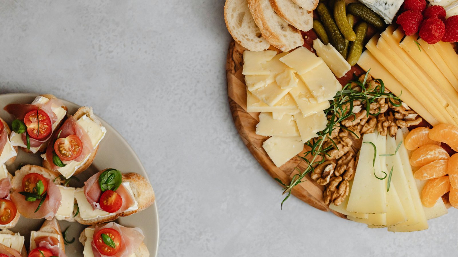 Artfully arranged charcuterie board with cured meats, cheeses, fruits, and nuts on marble surface.