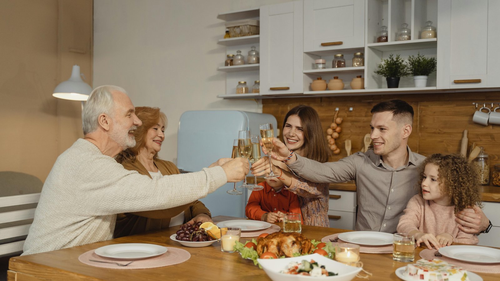 Multi-generational family toasting with wine around an elegantly plated dinner in a Fort Collins home.