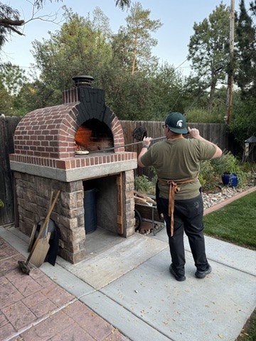 Chef at an outdoor wood-fired oven